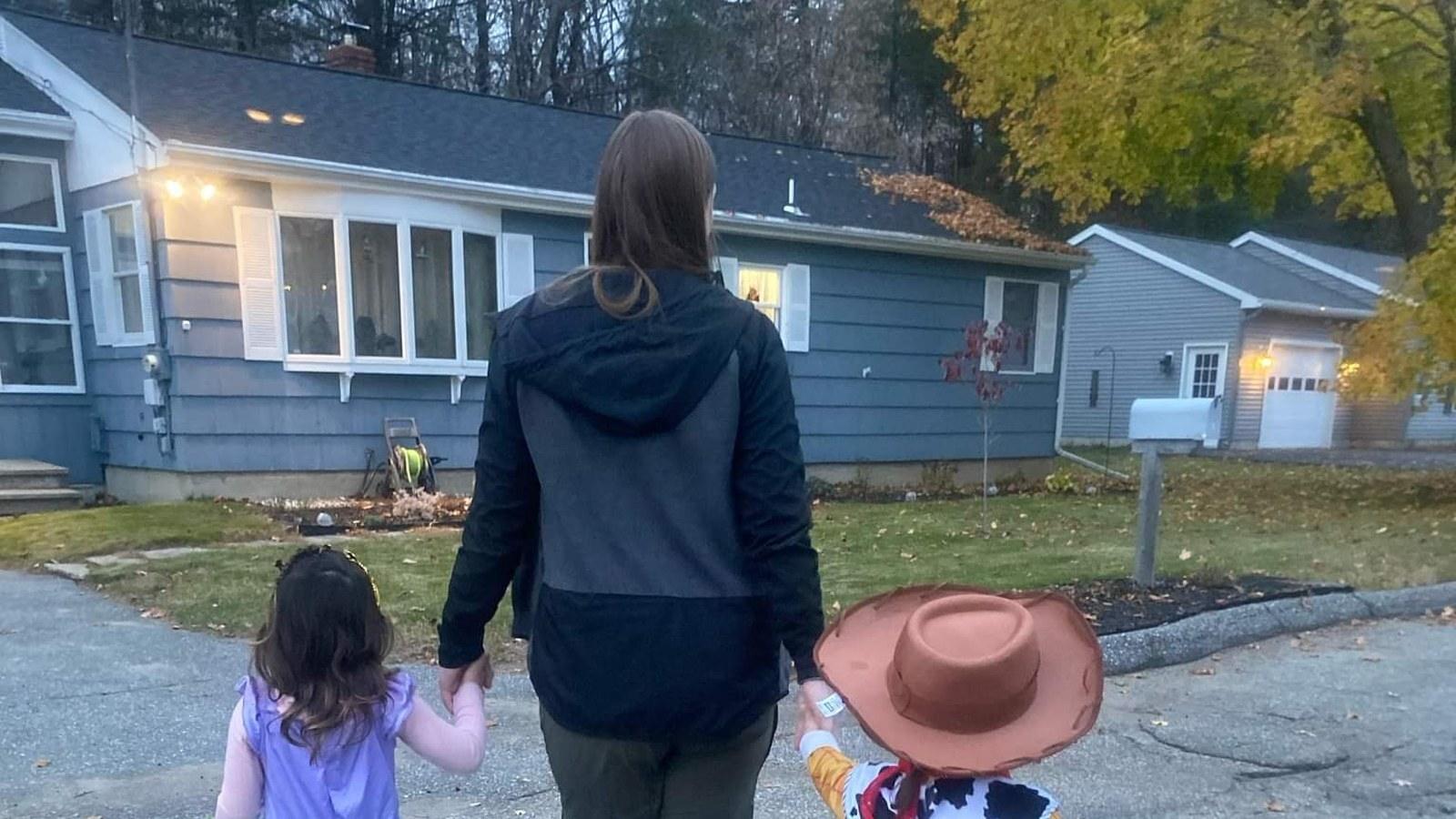 A family walking toward a house at dusk
